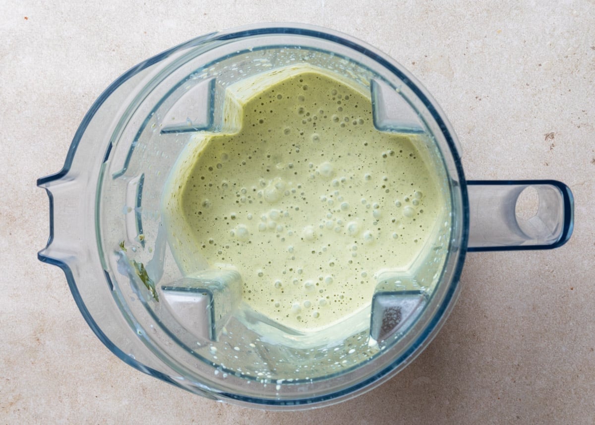 Overhead view of creamy cilantro jalapeno dressing blended smooth in a blender pitcher.